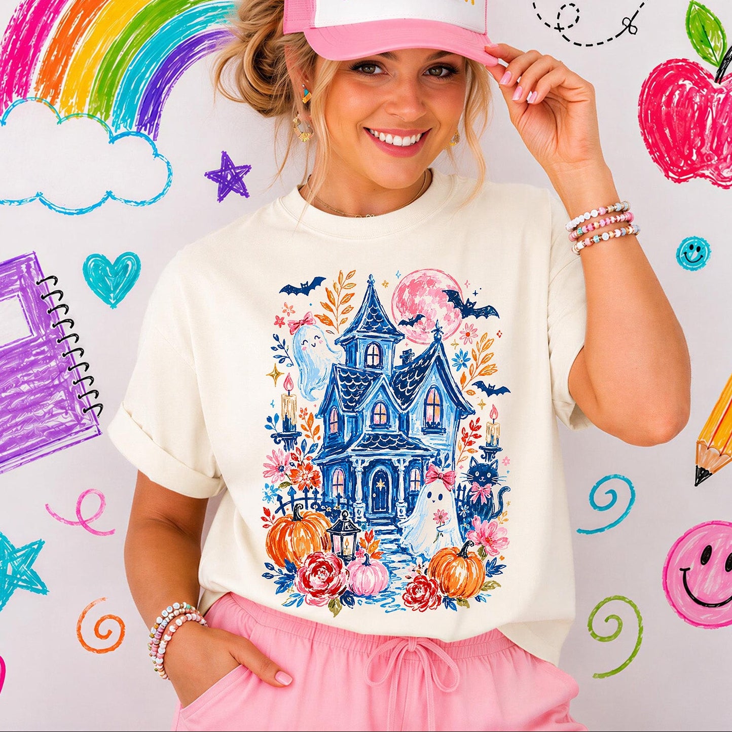 Vibrant Halloween DTF transfer design on a cream sweatshirt as seen in file Cute_Ghost The graphic features an intricate blue sketch-style haunted house surrounded by orange and pink pumpkins, autumn flowers, bats, candles, a black cat with a pink bow, and two cute ghosts wearing pink coquette bows. Ready to press heat transfer.