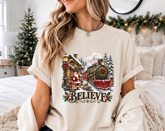 Believe Christmas DTF transfer featuring Santa Claus at a snowy train station with a vintage Christmas train, evergreen trees and holiday decorations