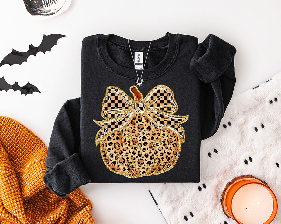 Leopard print pumpkin DTF transfer featuring a large black and tan checkerboard bow with sparkling gold style details for trendy fall apparel