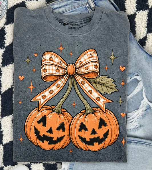 Girly Halloween DTF transfer featuring two jack-o-lantern pumpkins styled like cherries with an orange gingham pumpkin bow, hearts and sparkles