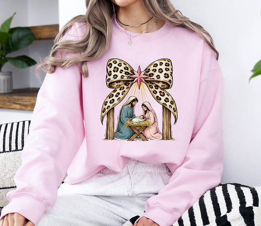 Coquette Nativity DTF transfer featuring Mary, Joseph and baby Jesus in a manger beneath the Christmas star with an oversized leopard print bow