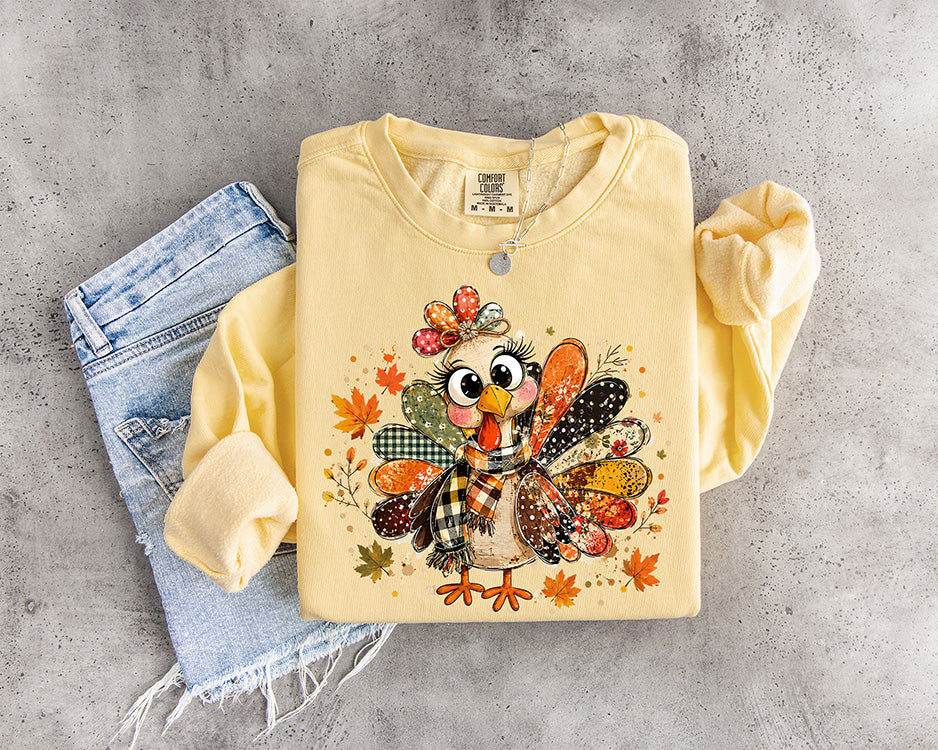 Cute patchwork Thanksgiving turkey DTF transfer with colorful patterned feathers plaid scarf bow and autumn leaves