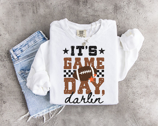 It's Game Day Darlin' DTF transfer with distressed brown and black lettering, football, checkerboard accents and orange stars