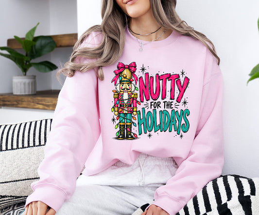 Nutty for the Holidays DTF transfer featuring a colorful Christmas nutcracker with pink bow, holiday lights and bright pink turquoise lettering