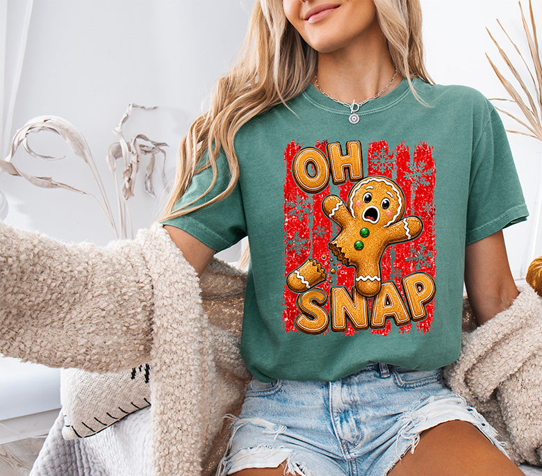 Oh Snap Christmas DTF transfer featuring a funny broken gingerbread man with bold retro lettering, snowflakes and distressed red background