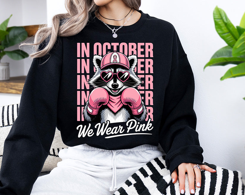 In October We Wear Pink breast cancer awareness DTF transfer featuring a raccoon with pink boxing gloves heart sunglasses and pink ribbon hat