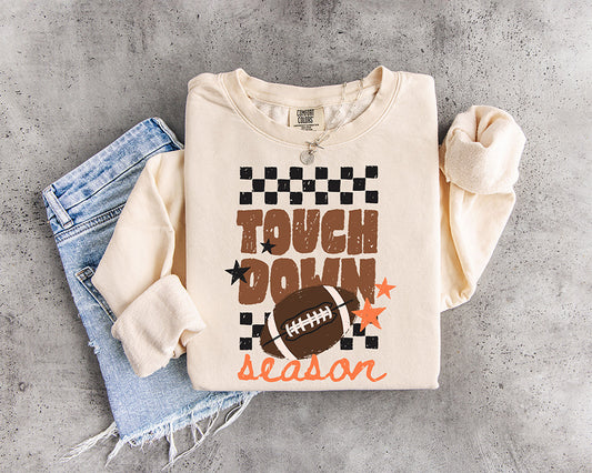 Touchdown Season football DTF transfer with distressed brown lettering, football, black checkerboard pattern and orange stars