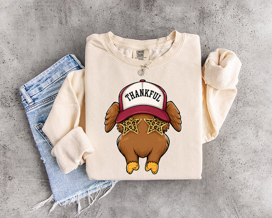 Thankful Turkey DTF transfer featuring a cute turkey wearing a Thankful trucker hat and leopard print star sunglasses