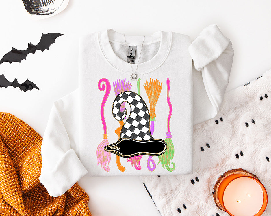 Preppy Halloween witch hat DTF transfer featuring a black and white checkerboard witch hat with colorful pink orange purple and green broomsticks