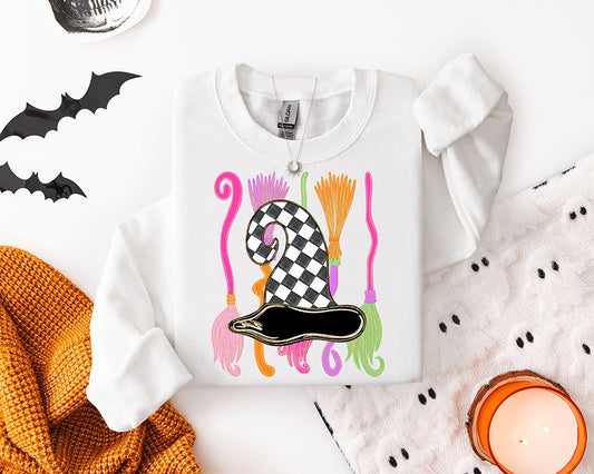 Preppy Halloween witch hat DTF transfer featuring a black and white checkerboard witch hat with colorful pink orange purple and green broomsticks